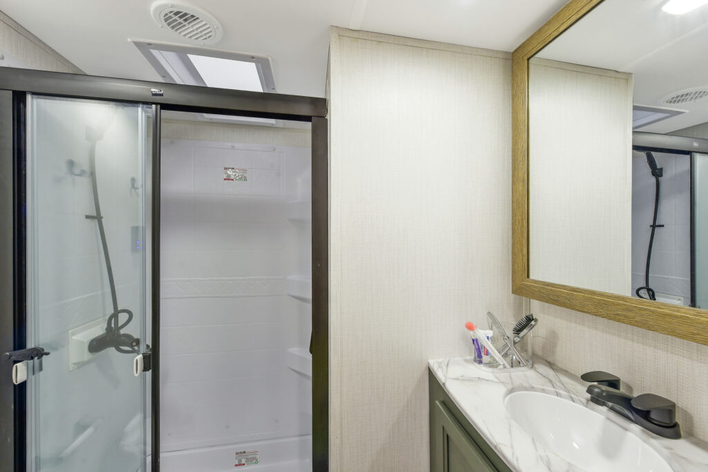 This image showcases the 2025 Eddie Bauer EBF 2500RK travel trailer, highlighting its sleek and contemporary design. The trailer features an attractive exterior with a striking color palette and stylish graphics, emphasizing its appeal to outdoor enthusiasts. Large windows enhance the overall look while providing ample natural light and beautiful views of the surroundings. The well-designed interior space is thoughtfully arranged for comfort and functionality, making it ideal for family adventures or relaxing weekend getaways. With its blend of modern aesthetics and practical features, the EBF 2500RK is ready for your next outdoor journey.