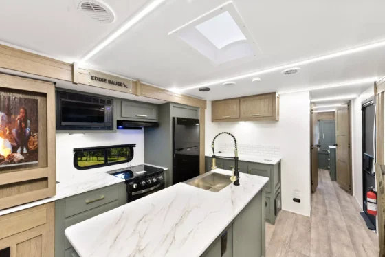 Kitchen interior of the 2025 Eddie Bauer CWEL 3311RL, featuring modern appliances, a spacious countertop, and a stylish design.
