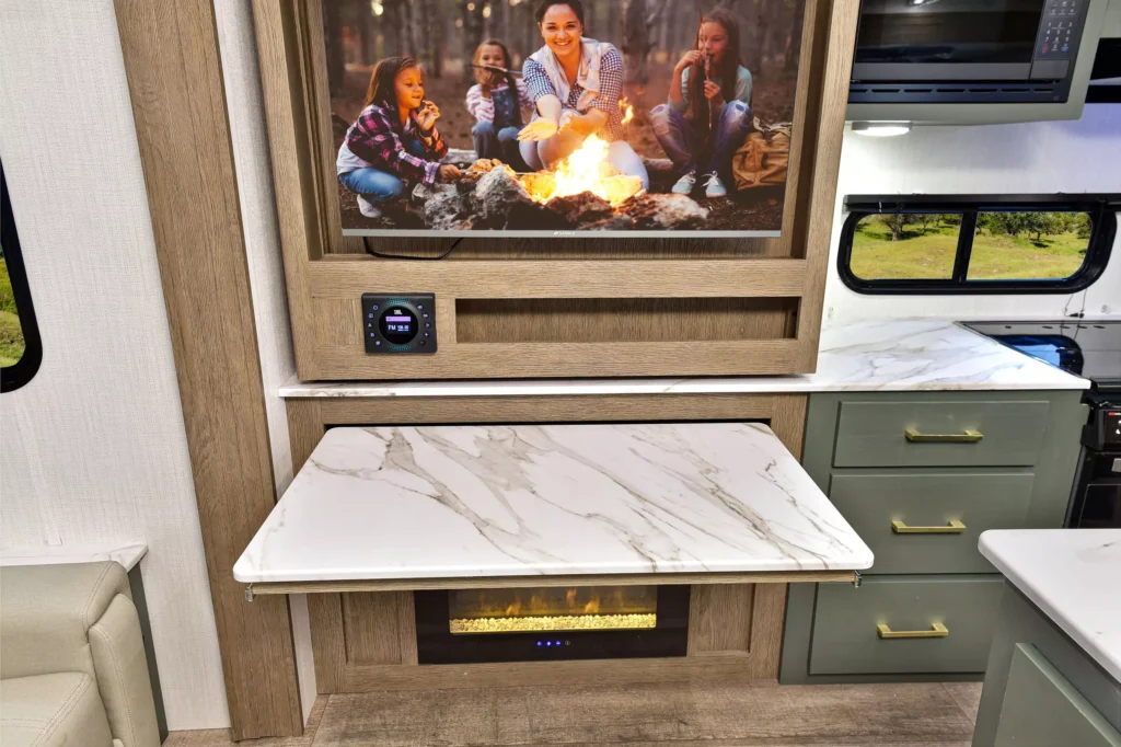 Pull-out table above the fireplace with a marble surface in the 2025 Eddie Bauer CWEL 3311RL RV.